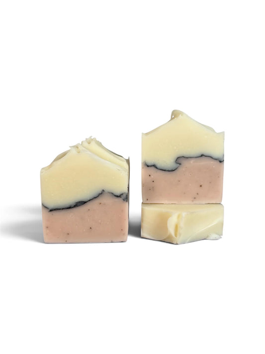 Three handmade soap bars with a marbled three-layer design of cream, dusty pink, and dark charcoal gray, photographed on a clean white background.