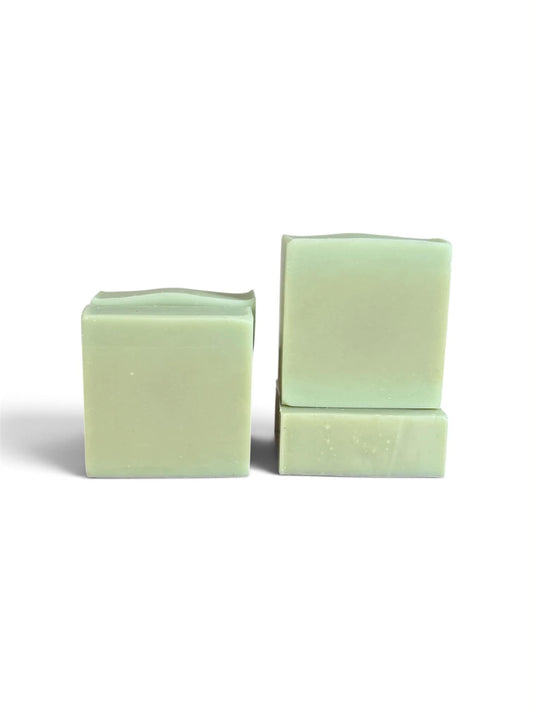 Two pale mint green bars of soap standing upright on a white background, one standing alone and the other stacked with a smaller piece in front.