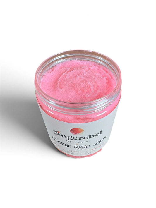 A clear plastic jar of Ringerebel Foaming Sugar Scrub with a white label, filled with bright pink foaming scrub, shown on a white background.