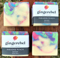 Two bars of colorful soap with 'gingerebel' packaging on a wooden surface.