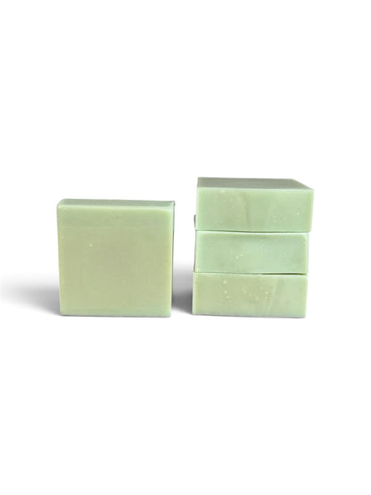Three pale mint green rectangular bars of soap standing upright on a white background, with one bar standing alone on the left and two stacked on the right.