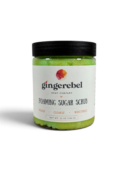 A jar of green sugar scrub with a white label on a white background. 
