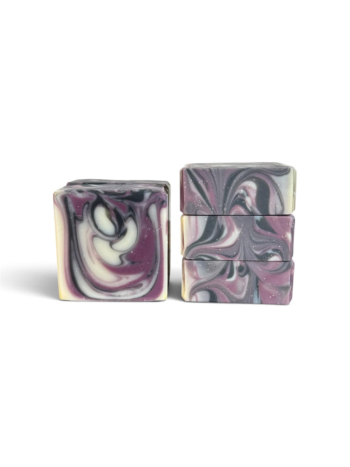 Two stacks of rectangular marbled soap bars with swirls of purple, white, and black, photographed on a clean white background.