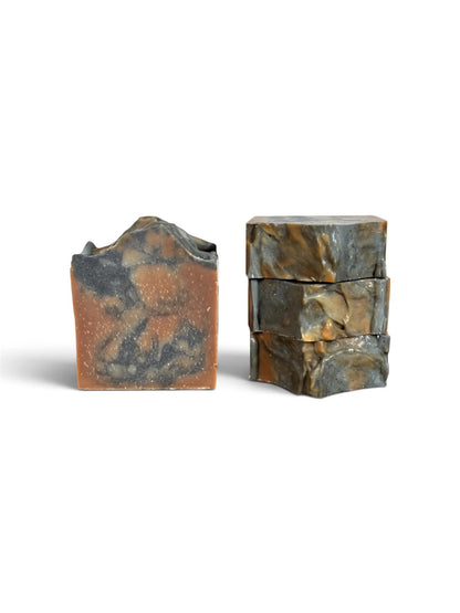 Two rectangular bars of artisanal soap with a natural stone-like marbled pattern, one standing upright and the other stacked, on a white background.