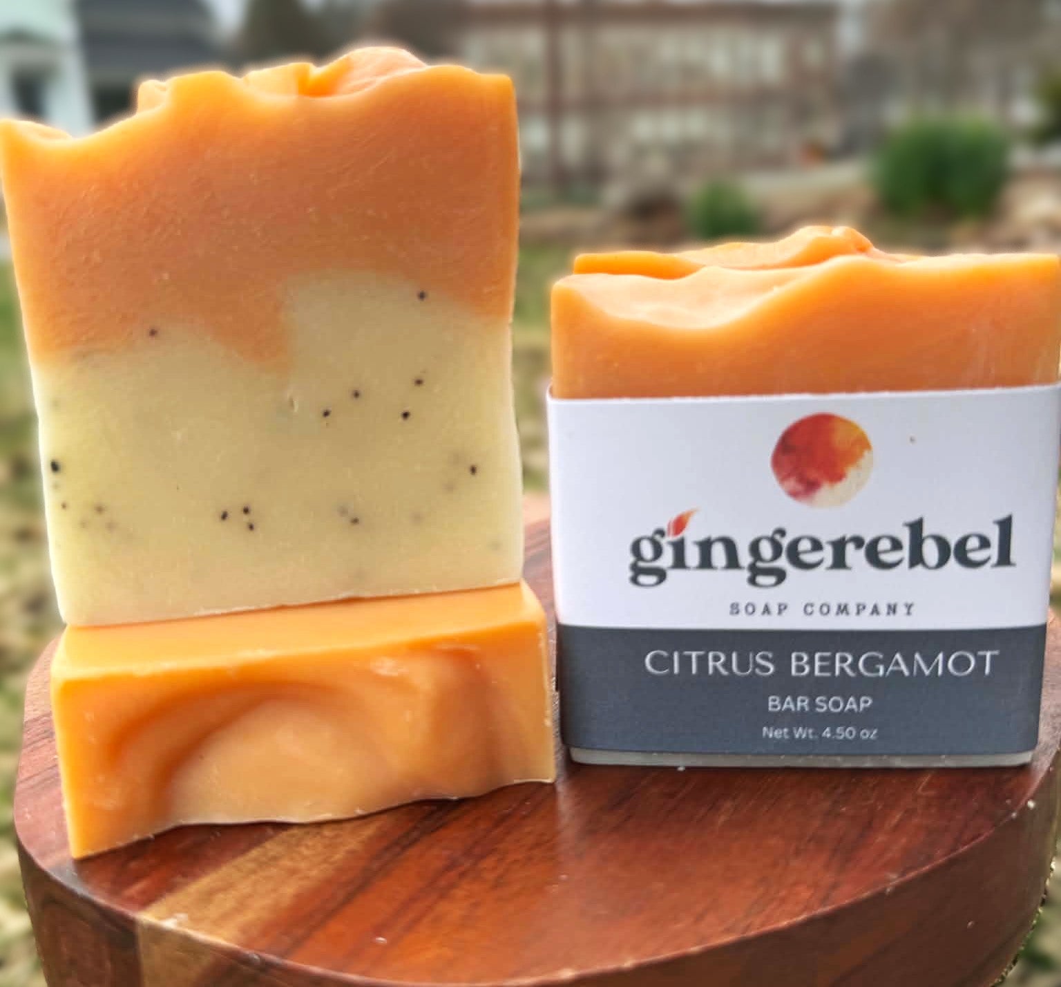 Three layered soap bar with a 'gingerebel' soap packaging on a wooden surface.
