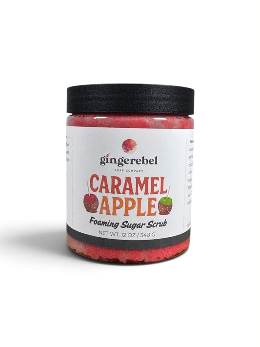 A jar of Gingerebel Caramel Apple Foaming Sugar Scrub with a black lid and white label, set against a plain white background.