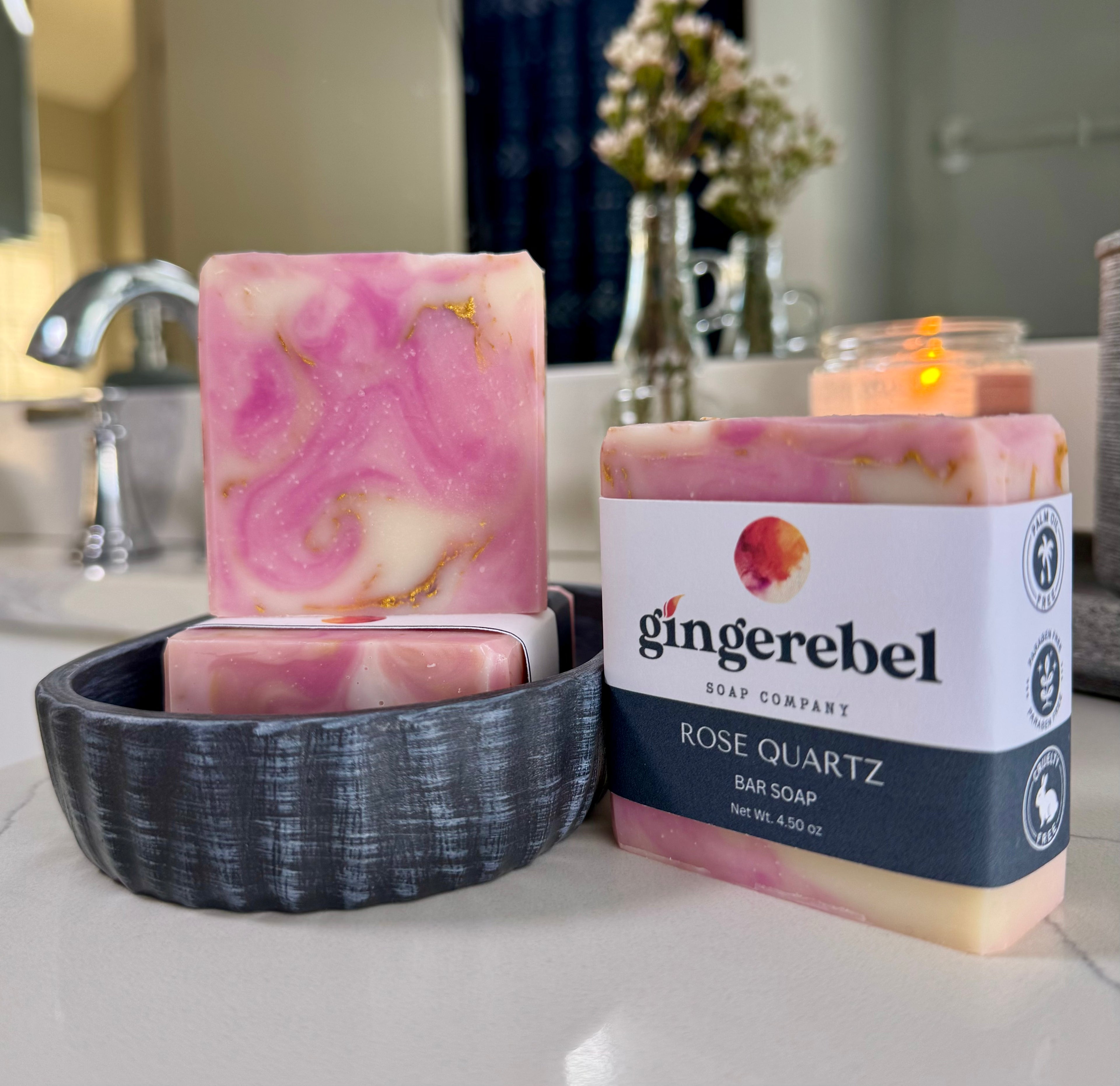 Pink marbled soap bar with 'ginger rebel' packaging on a bathroom counter.