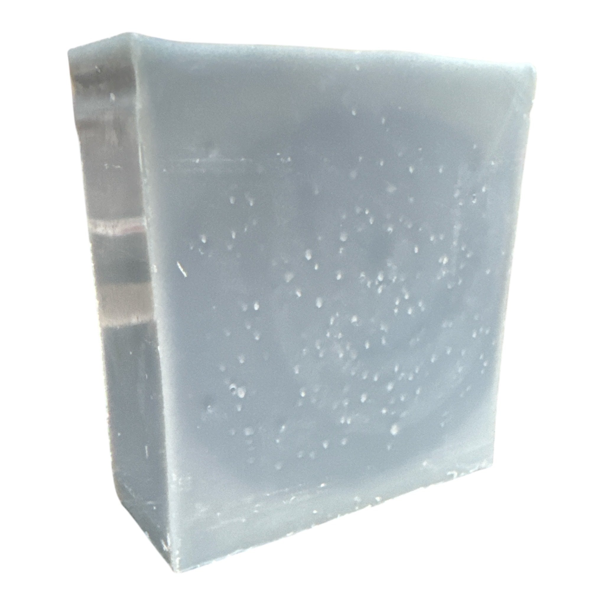Block of bluish-gray soap with white specks on a white background