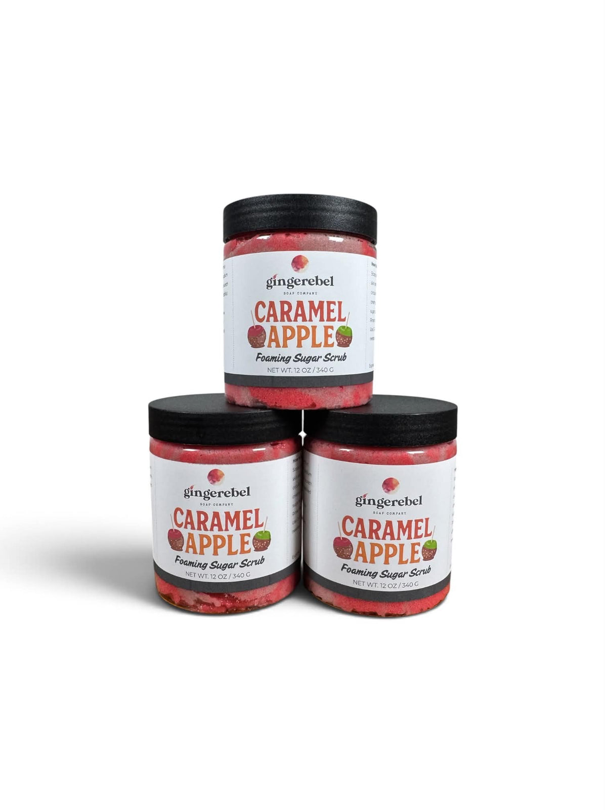 Three jars of gingerebel Caramel Apple Foaming Sugar Scrub stacked in a pyramid arrangement on a white background.