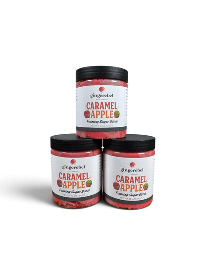 Three jars of gingerebel Caramel Apple Foaming Sugar Scrub stacked in a pyramid arrangement on a white background.