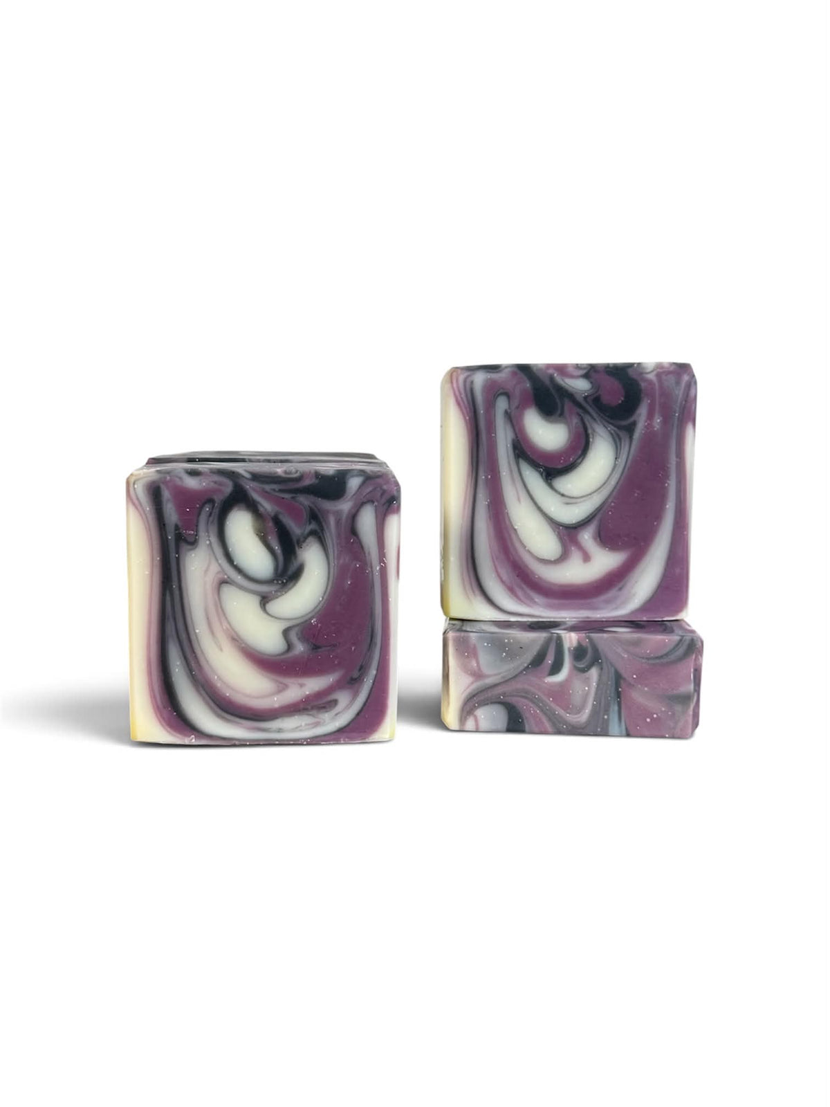 Three rectangular bars of soap with a marbled swirl pattern in purple, white, and black, displayed on a clean white background.