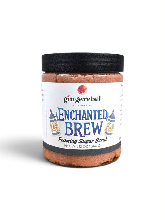 A jar of Gingerebel Enchanted Brew Foaming Sugar Scrub with a black lid and white label, set against a plain white background.