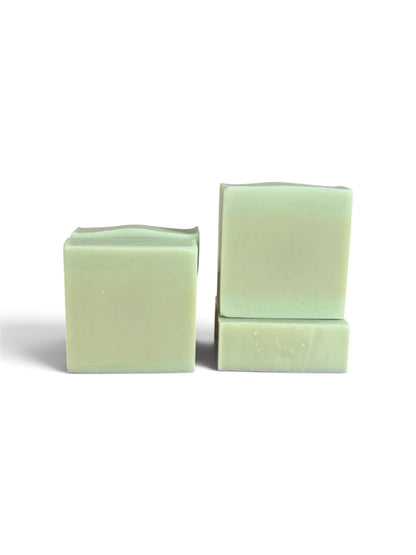 Two pale mint green bars of soap standing upright on a white background, one standing alone and the other stacked with a smaller piece in front.