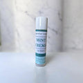 Lip balm tube labeled 'Mint Crema' on a marble background